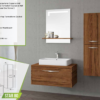 Modern 'Star 80' bathroom vanity set with a single soft-close drawer and thermoform-coated MDF body. The set includes a sleek ceramic washbasin and a rectangular lighted mirror mounted on a gray wall, complemented by a tall, slender storage cabinet.