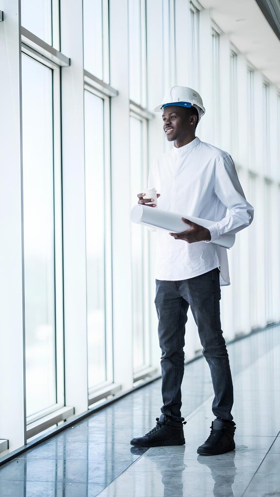 young afro american engineer with blue prints front panoramic windows office 1 1